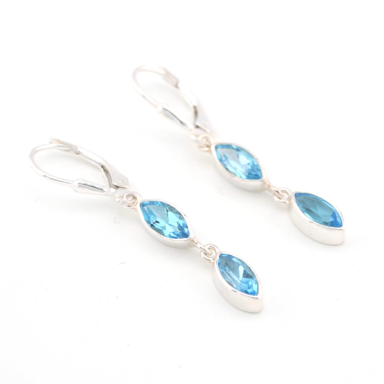 Silver earrings with blue gemstones on a white background