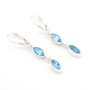 Silver earrings with blue gemstones on a white background