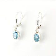 Silver earrings with blue gemstones on a white background