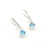 Pair of silver earrings with blue gemstones on a white background