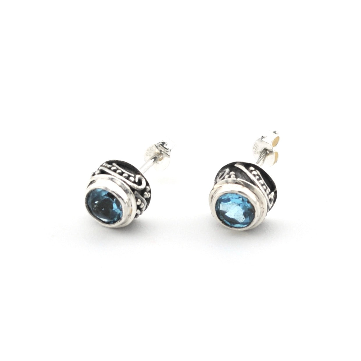 Pair of silver earrings with blue gemstones on a white background