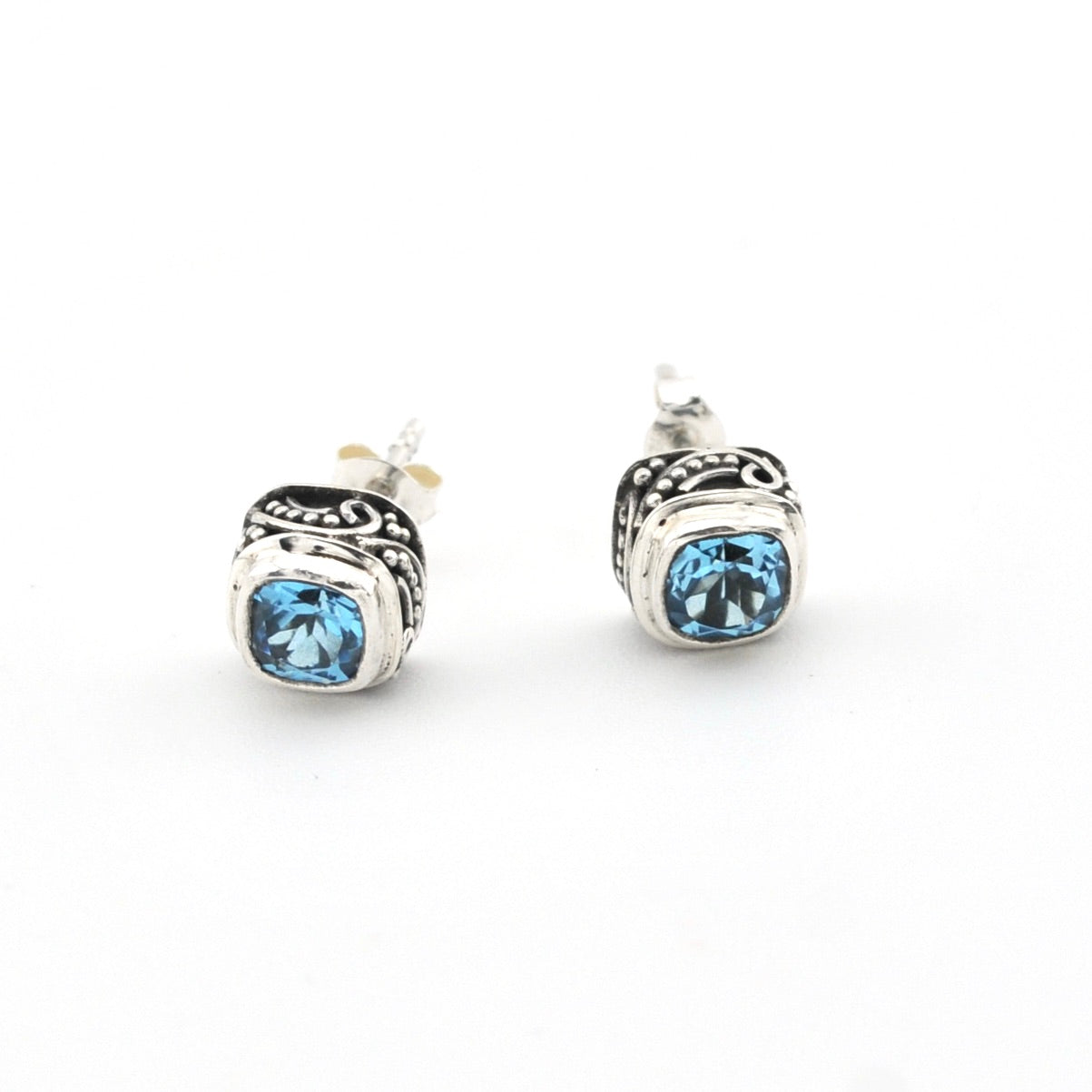 Pair of silver stud earrings with blue gemstones on a white background