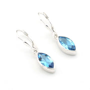 Silver earrings with blue teardrop-shaped gemstones on a white background