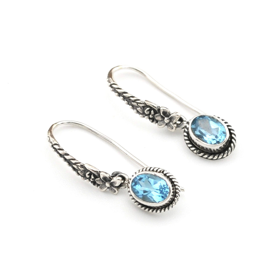 Silver earrings with blue gemstones on a white background