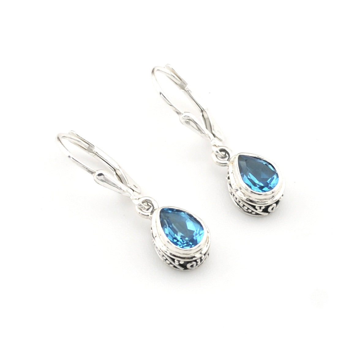 Silver earrings with blue gemstones on a white background