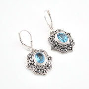 Silver earrings with blue gemstones on a white background
