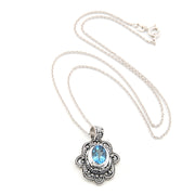 Silver necklace with a pendant featuring a blue gemstone on a white background