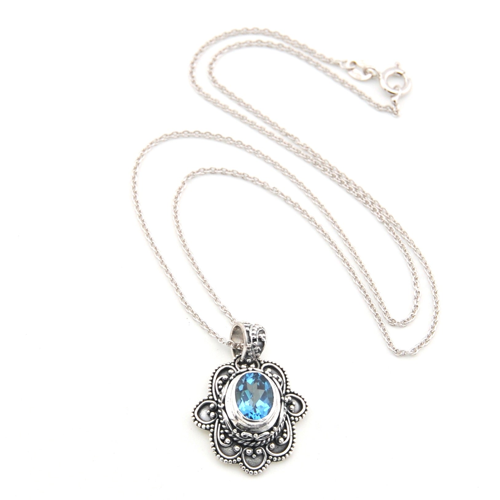 Silver necklace with a pendant featuring a blue gemstone on a white background