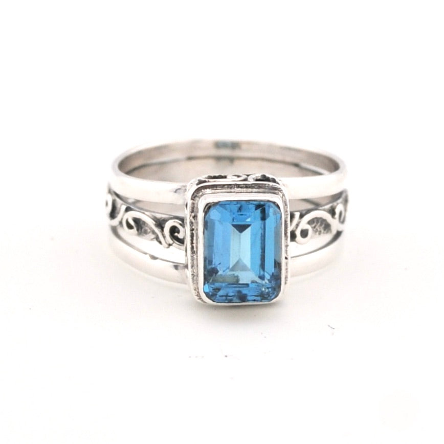 Silver ring with a blue gemstone on a white background