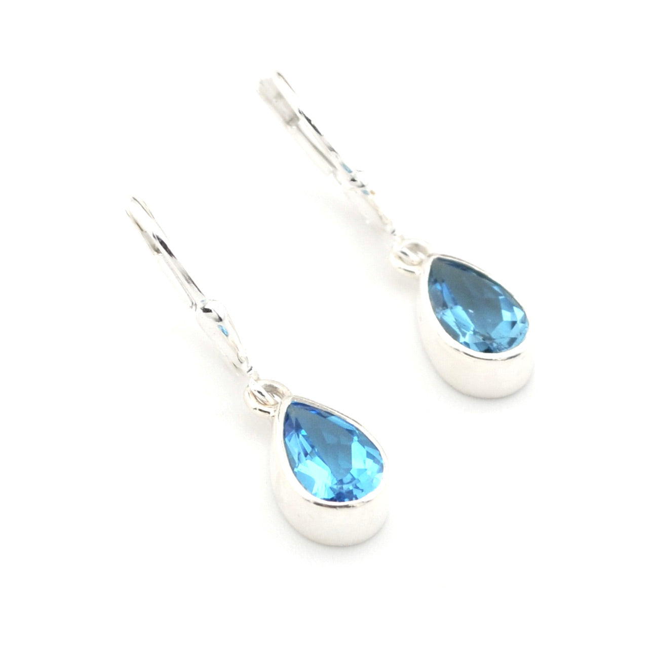 Silver earrings with blue teardrop-shaped gemstones on a white background