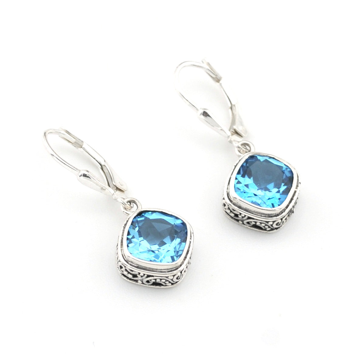 Silver earrings with blue gemstones on a white background