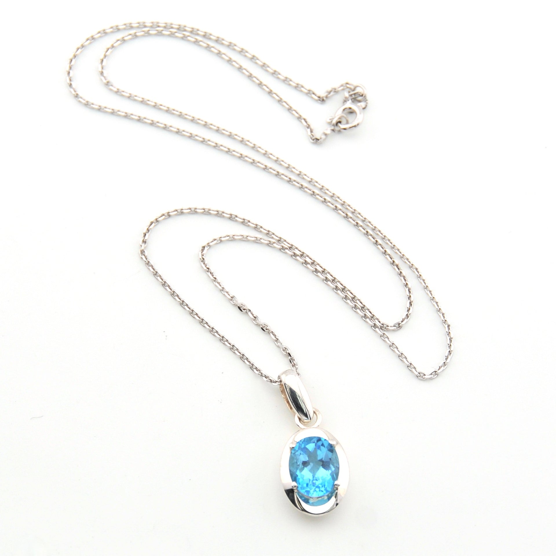 Silver necklace with a blue gemstone pendant on a white background