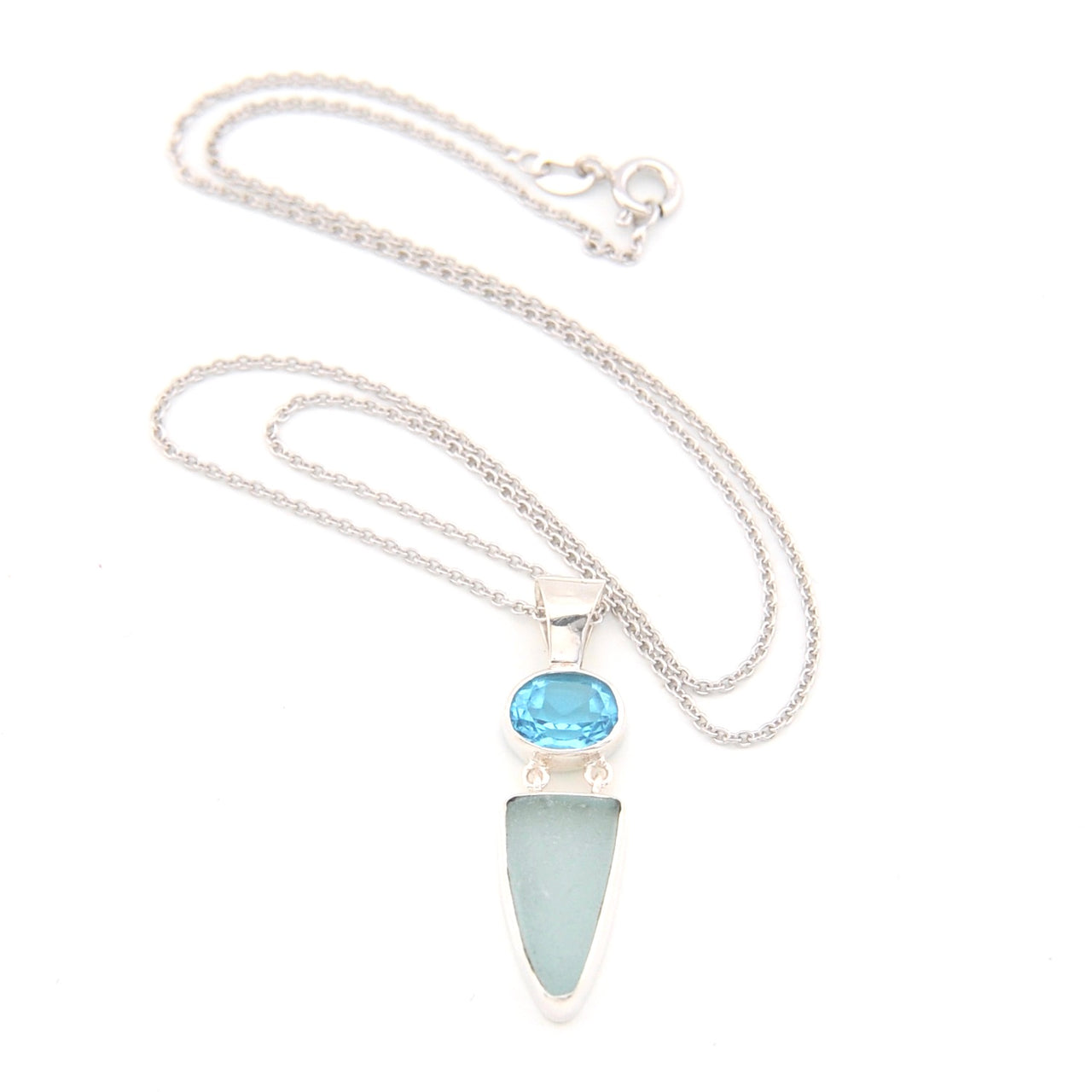 Necklace with a blue gemstone and light blue pendant on a white background