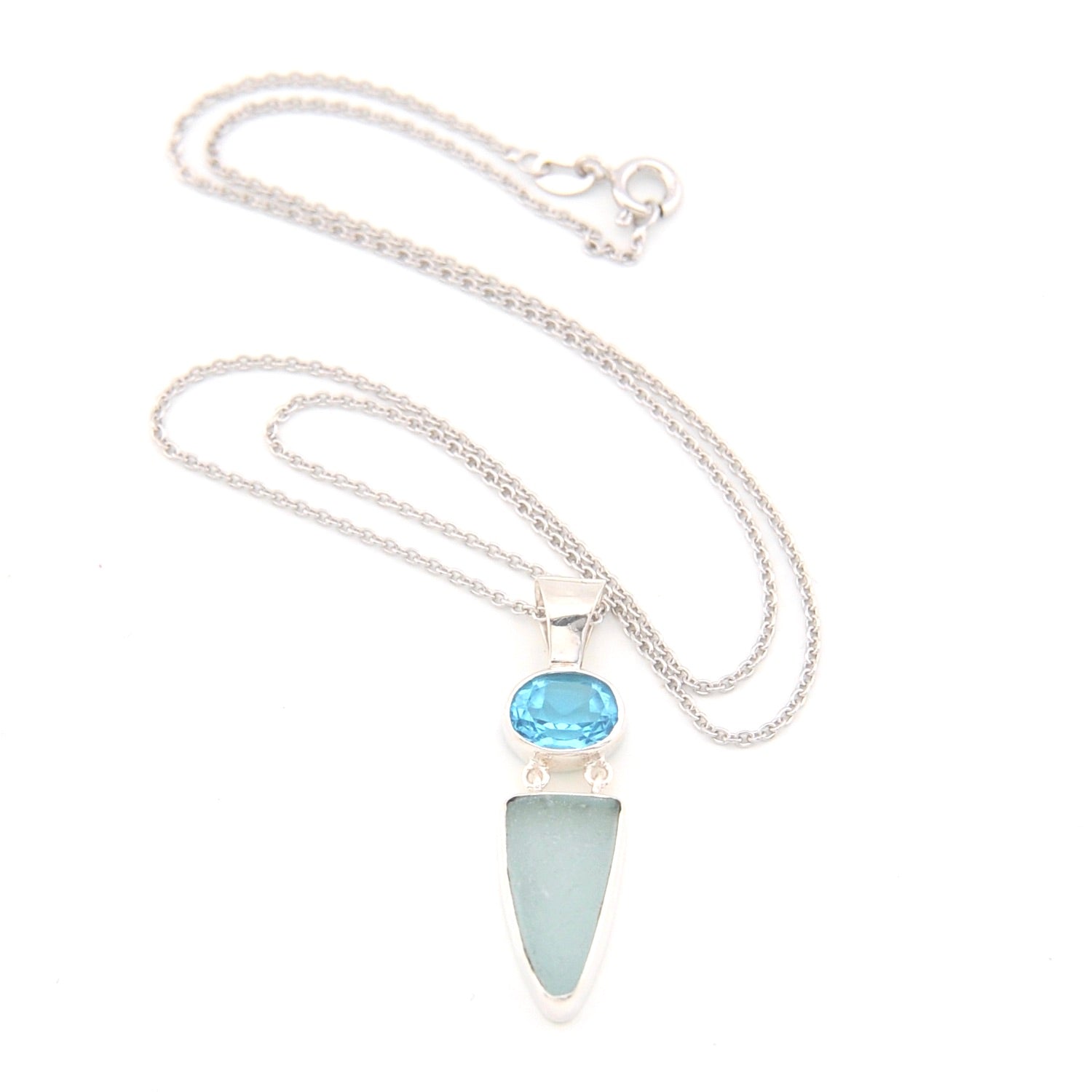 Necklace with a blue gemstone and light blue pendant on a white background