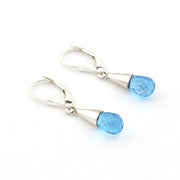 Pair of silver earrings with blue gemstones on a white background