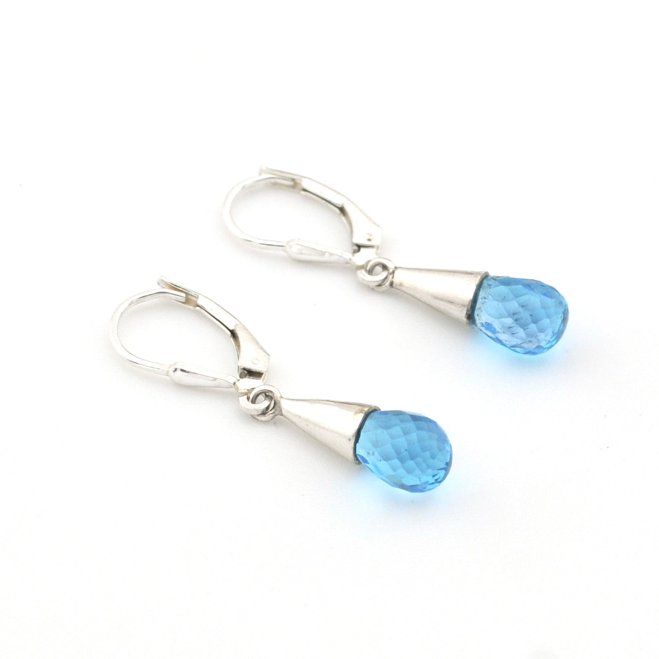 Pair of silver earrings with blue gemstones on a white background