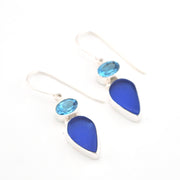 Blue teardrop earrings with silver accents on a white background