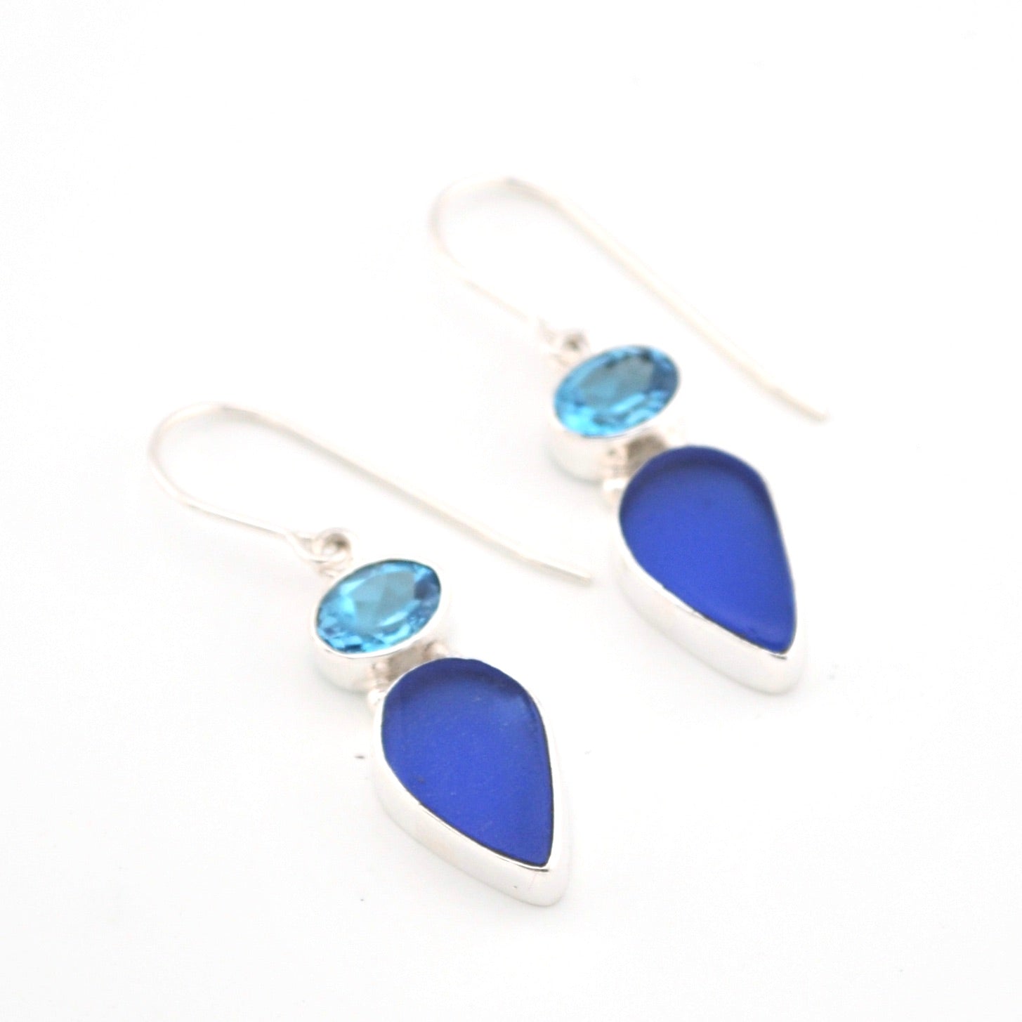 Blue teardrop earrings with silver accents on a white background