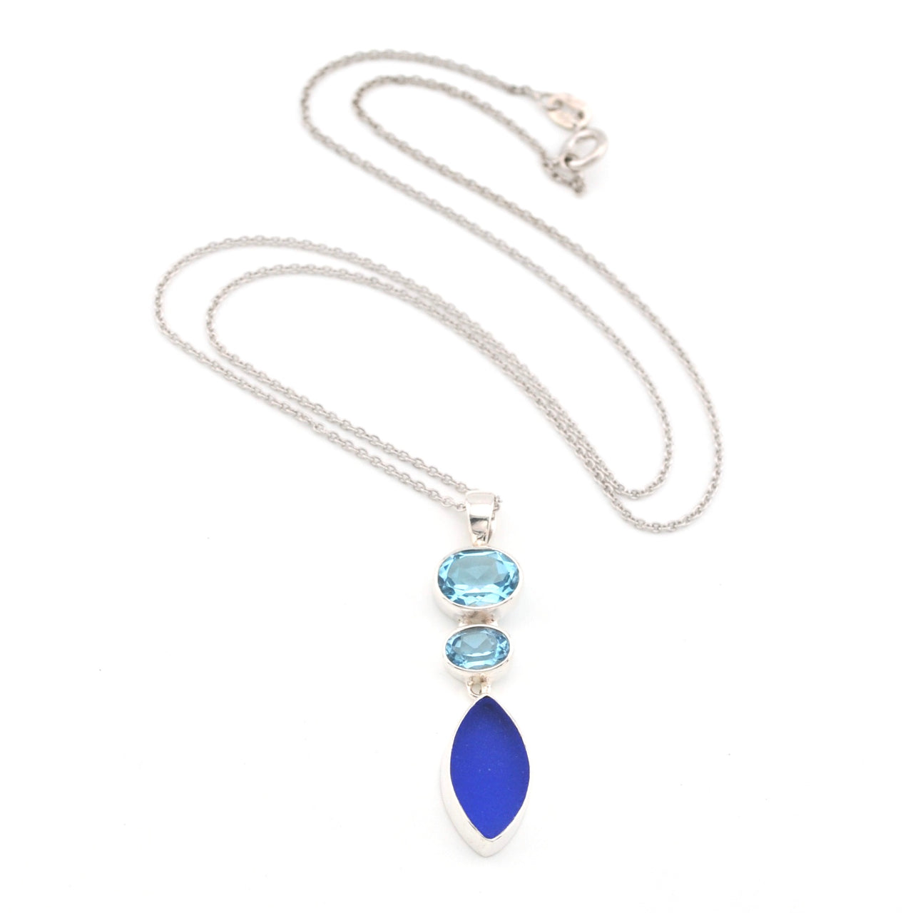 Necklace with blue topaz and blue sea glass pendant on a white background