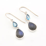 Pair of silver earrings with teardrop-shaped gemstones on a white background