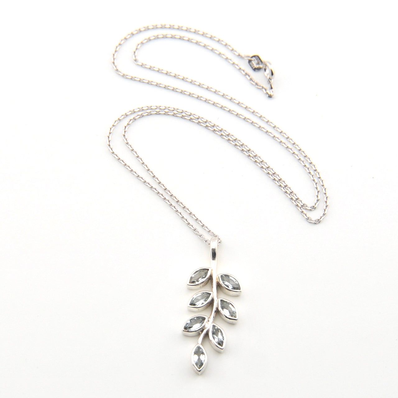 Silver necklace with leaf-shaped pendant on a white background