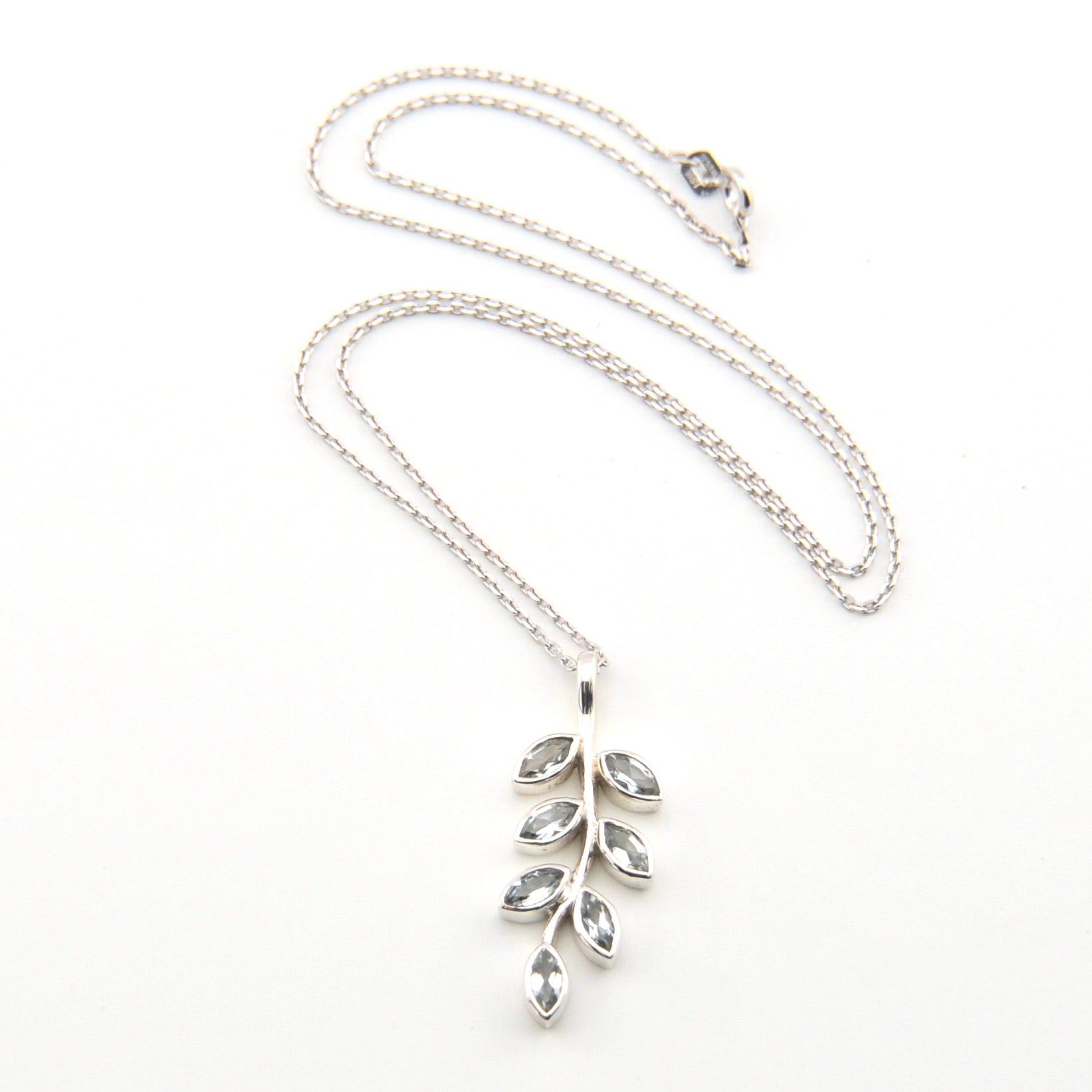 Silver necklace with leaf-shaped pendant on a white background