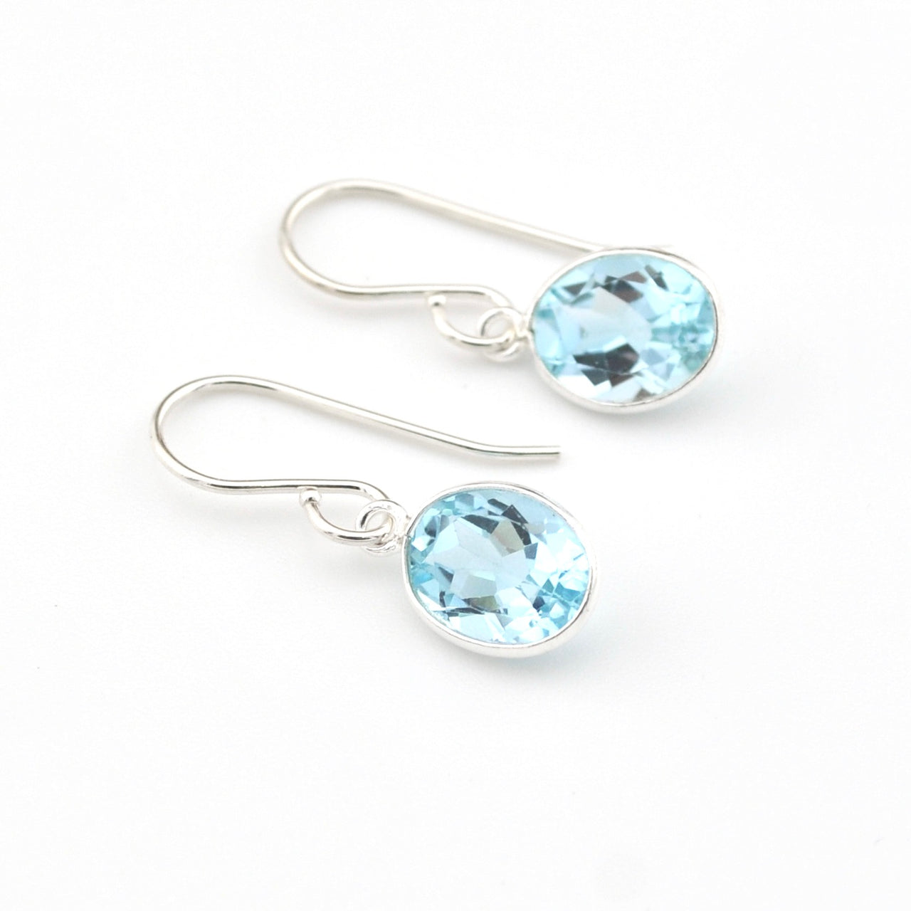 Silver earrings with blue gemstones on a white background