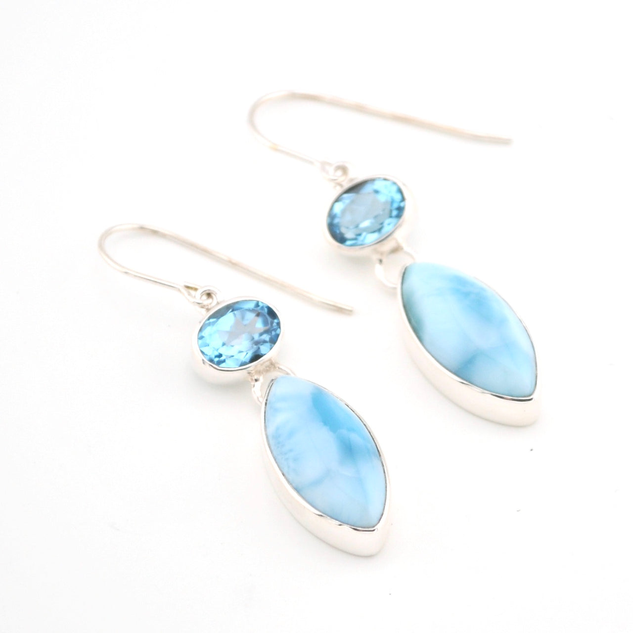 Silver earrings with blue marquise-shaped stones on a white background