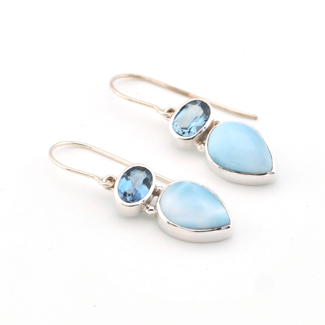 Pair of earrings with blue teardrop-shaped stones on a white background