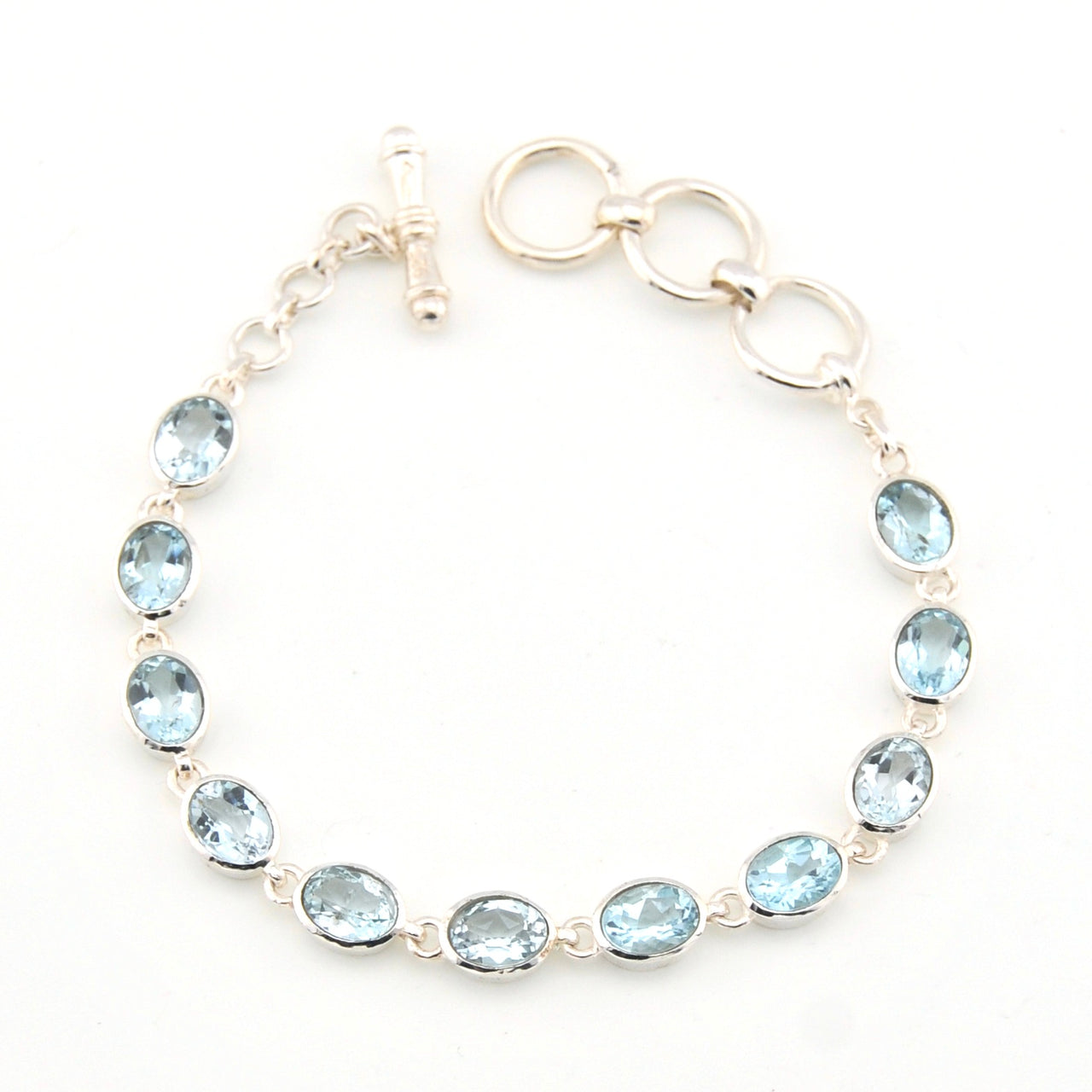 Silver bracelet with blue gemstones on a white background