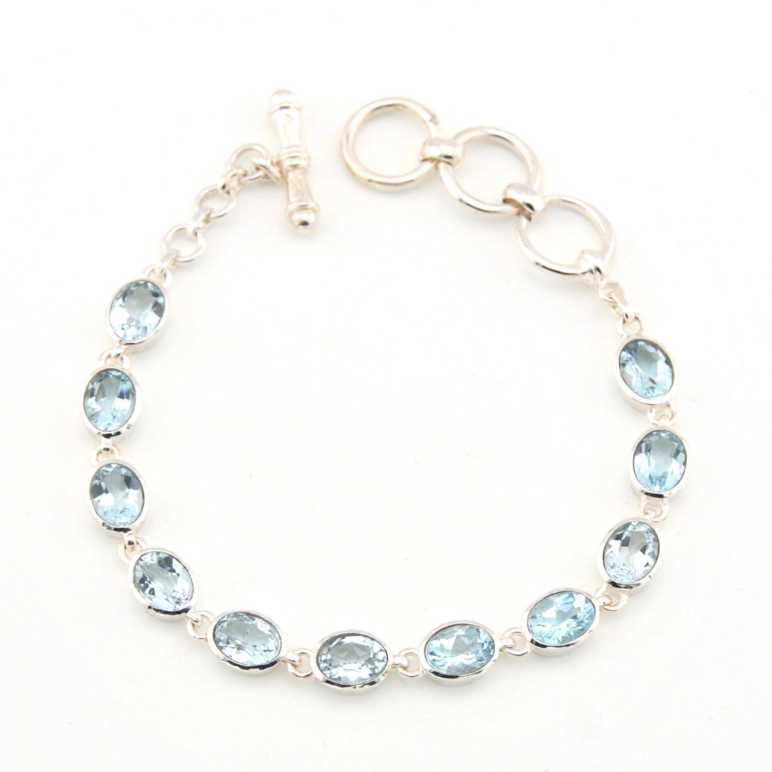 Silver bracelet with blue gemstones on a white background