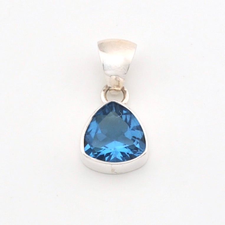 Silver pendant with a blue trillion-shaped gemstone on a white background