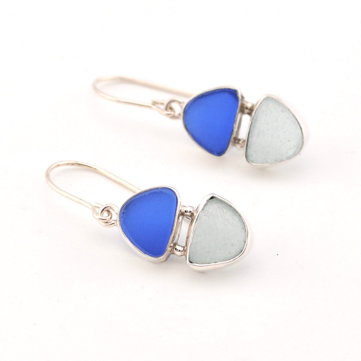 Pair of earrings with blue and aqua triangular glass stones on a white background
