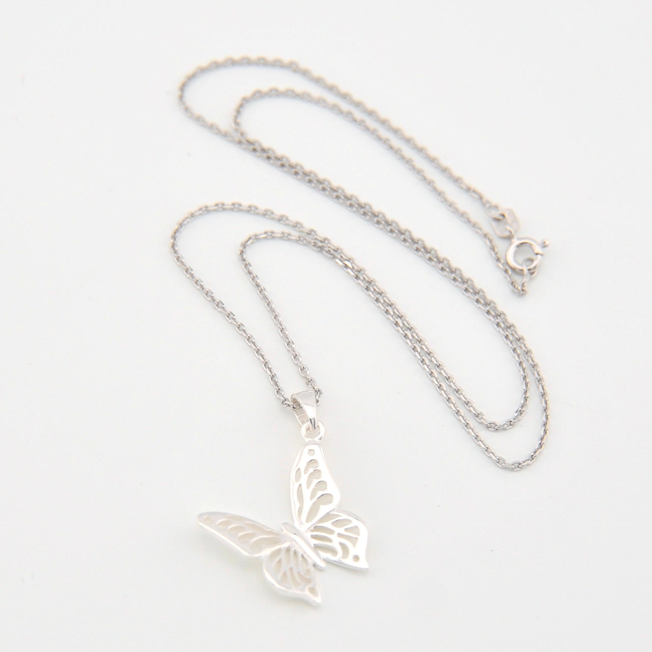 Silver butterfly necklace on a white background
