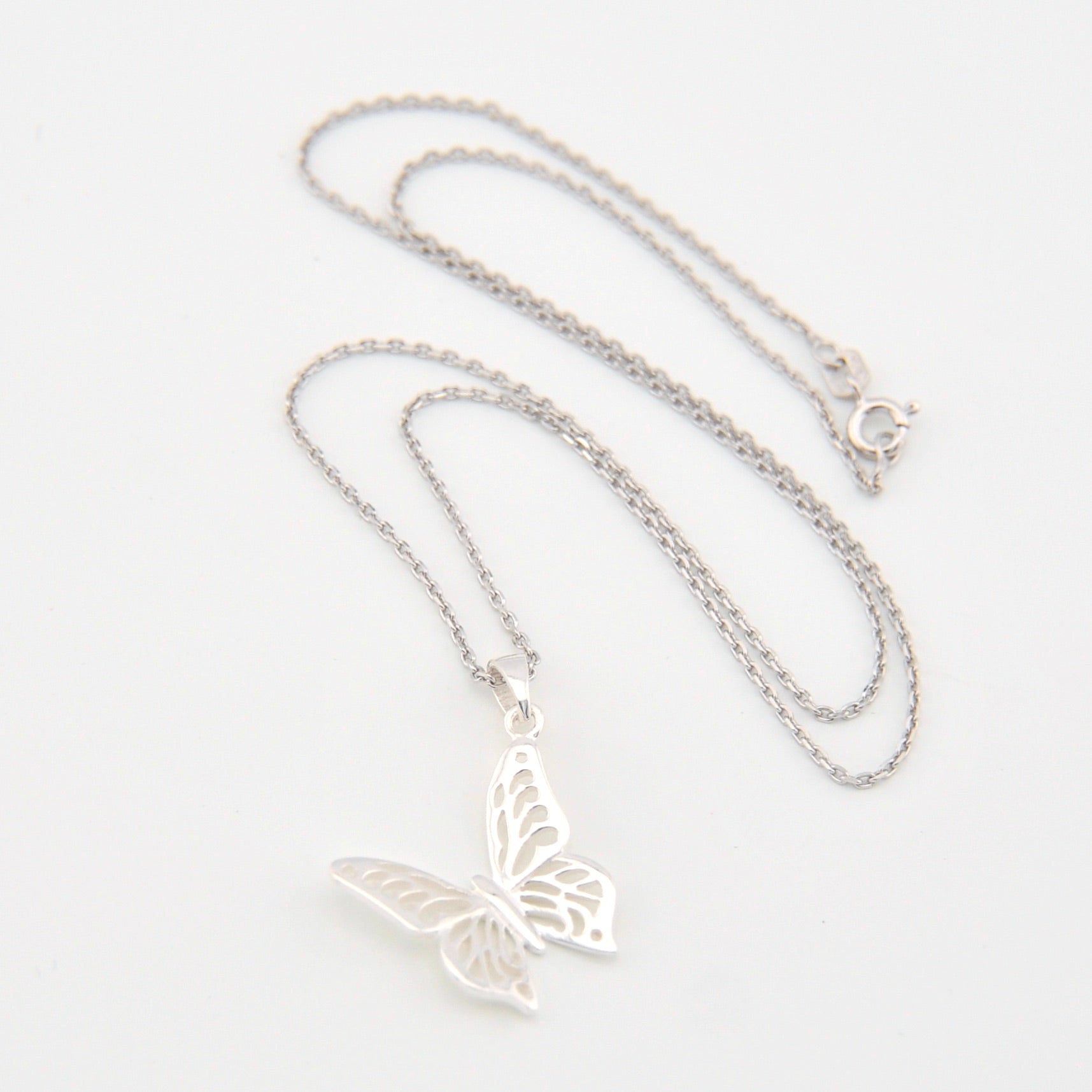 Silver butterfly necklace on a white background