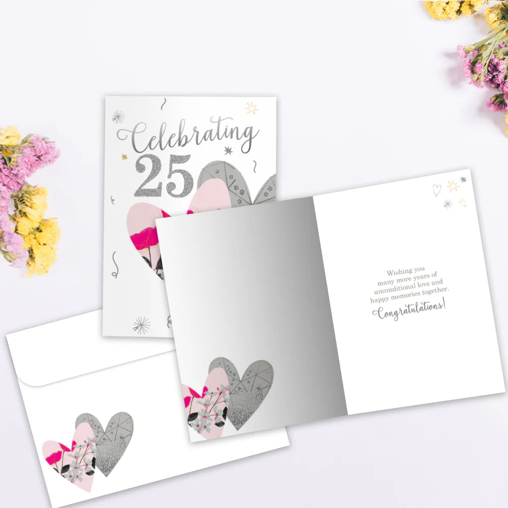 Greeting card with heart designs and text on a white surface with flowers.