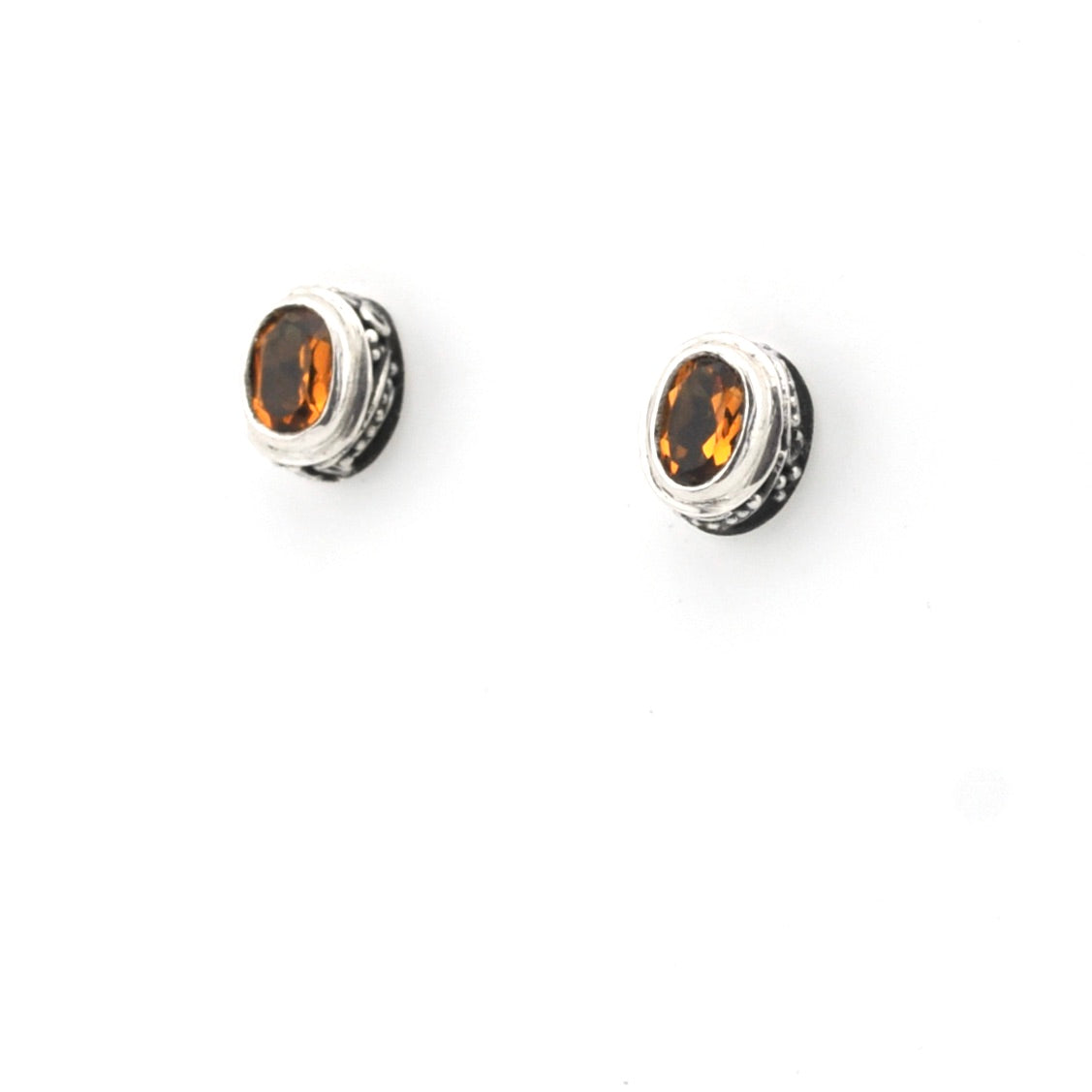 Pair of silver earrings with citrine stones on a white background