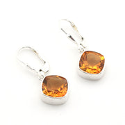 A pair of silver leverback earrings with cushion-cut amber-orange gemstones, displayed on a clean white background.