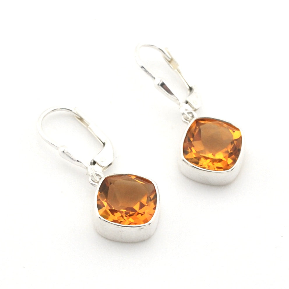 A pair of silver leverback earrings with cushion-cut amber-orange gemstones, displayed on a clean white background.