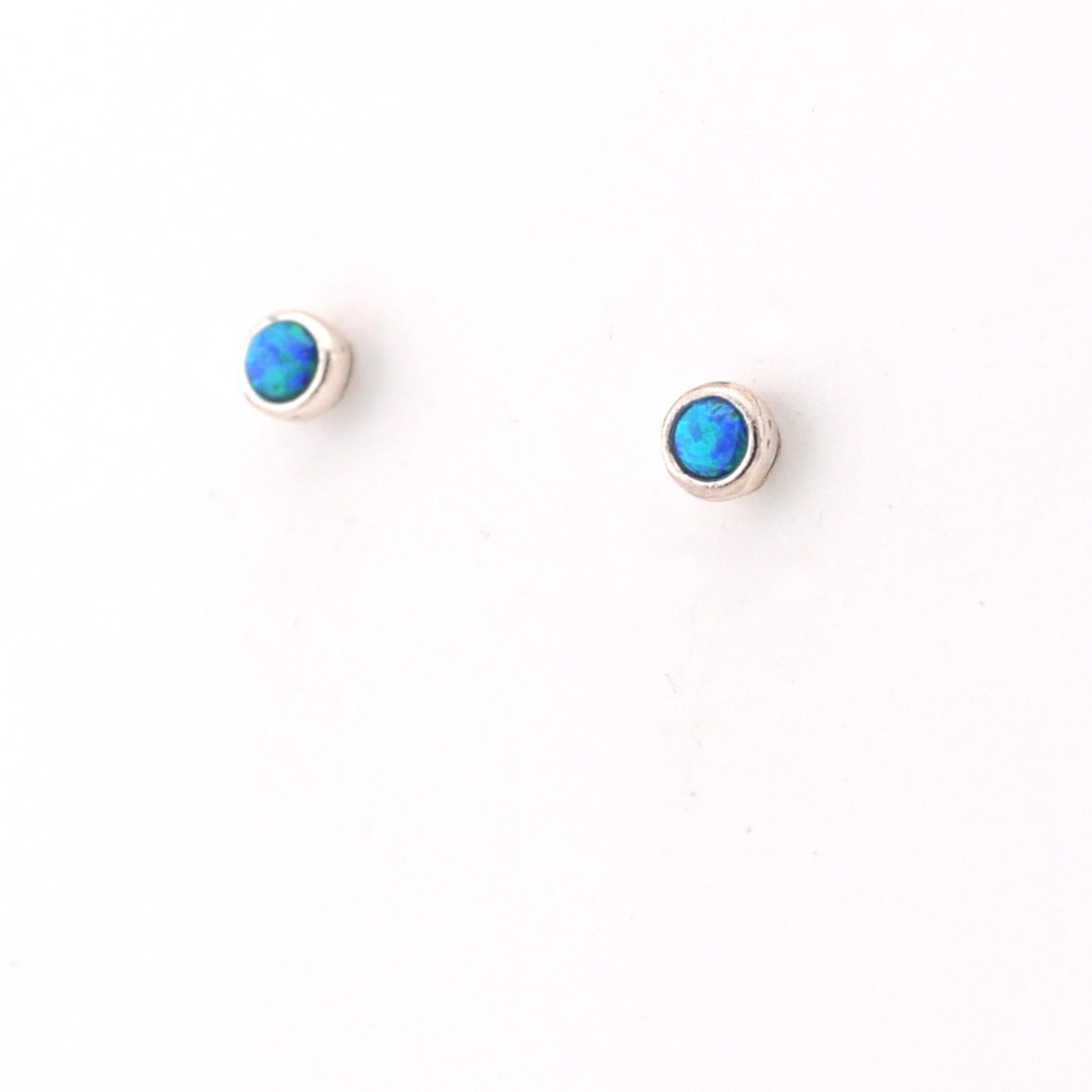 Pair of silver earrings with blue gemstones on a white background
