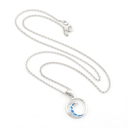 Silver necklace with a round pendant featuring a blue wave on a white background