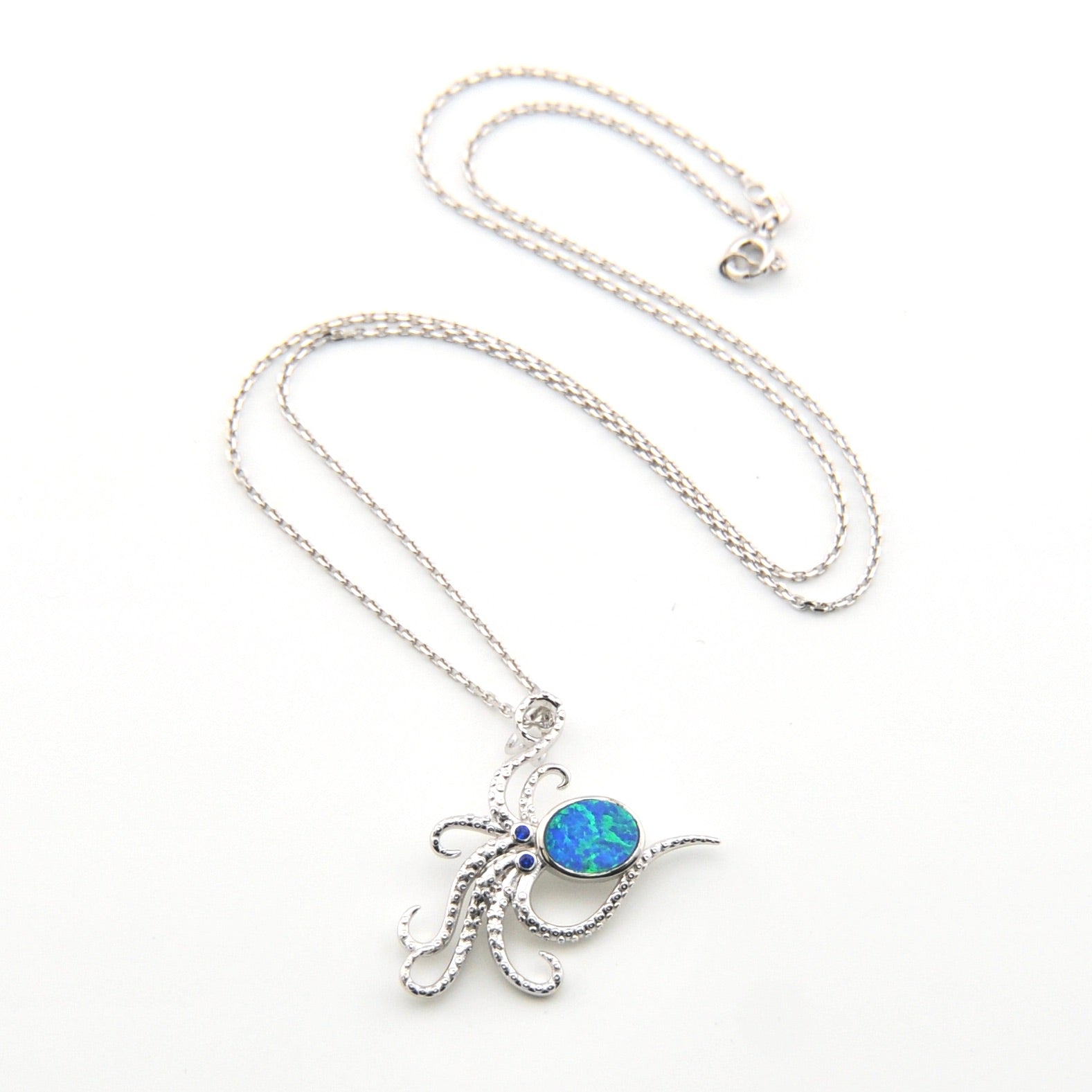 Silver necklace with a blue pendant on a white background