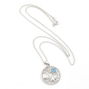 Silver necklace with a round pendant featuring a blue gemstone on a white background