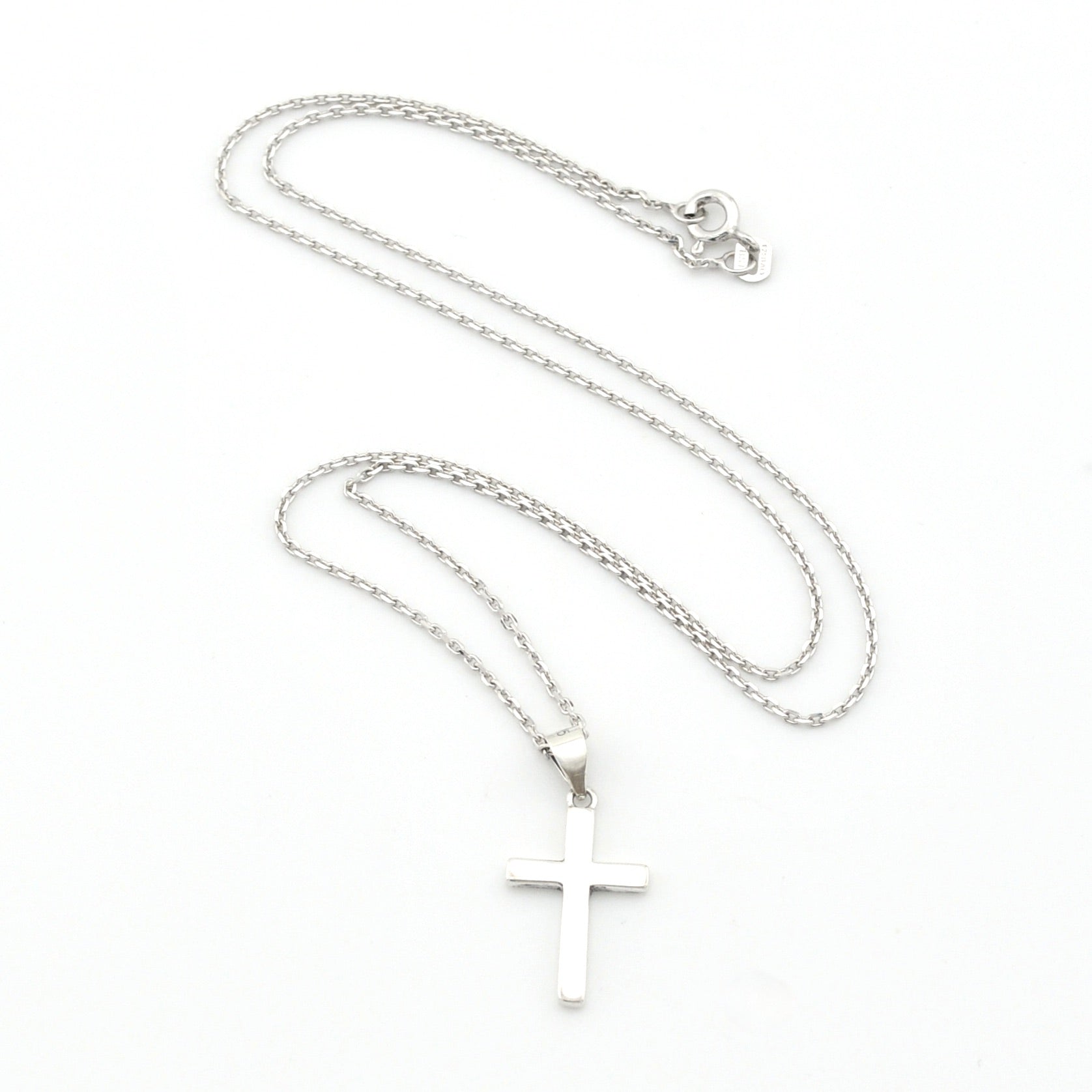 Silver cross necklace on a white background