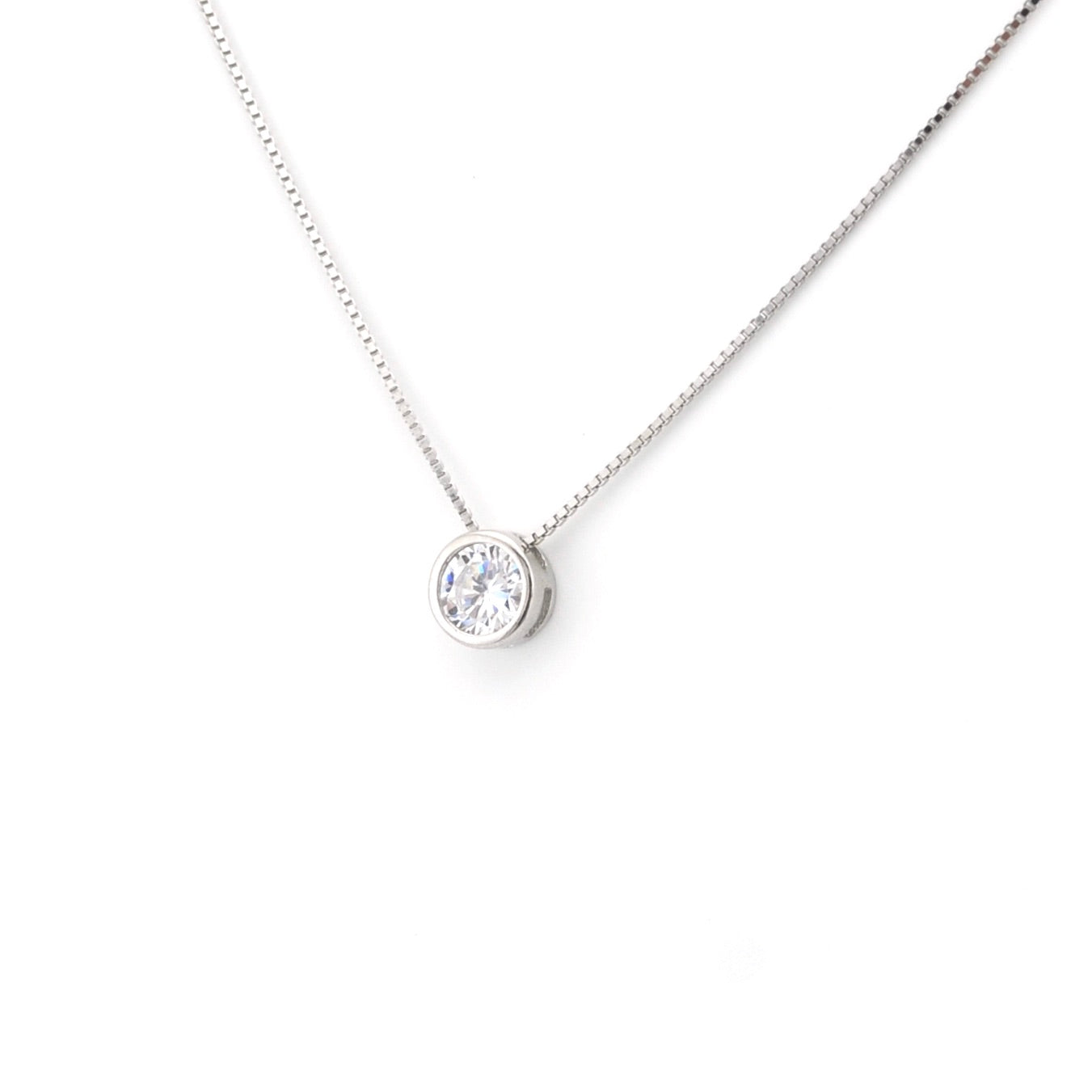 Silver necklace with a round pendant on a white background