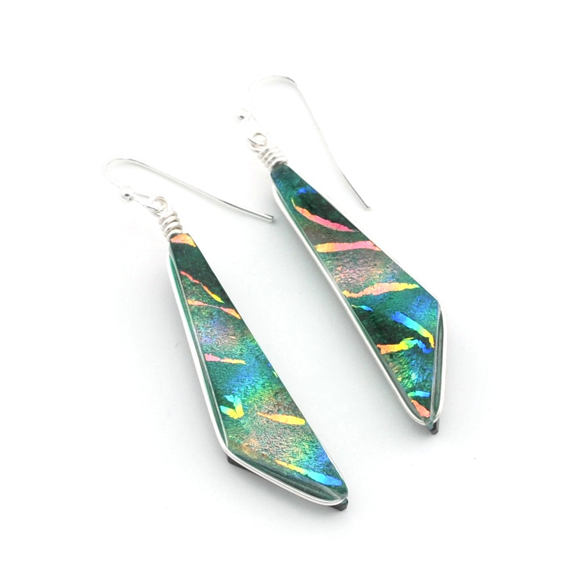 A pair of silver dangle earrings with geometric, arrowhead-shaped green iridescent dichroic glass, shown on a plain white background.