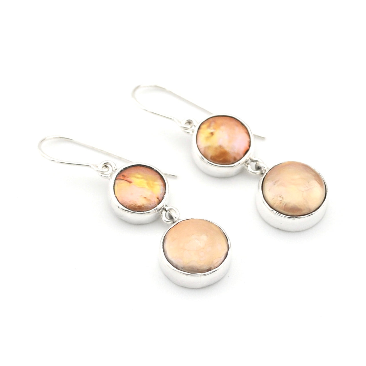 Pair of earrings with round peach-colored gemstones on a white background