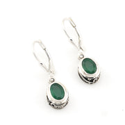Silver earrings with green gemstones on a white background