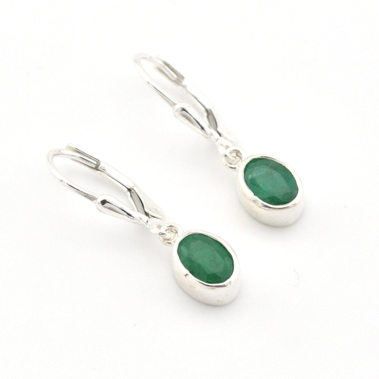 Pair of silver earrings with green gemstones on a white background