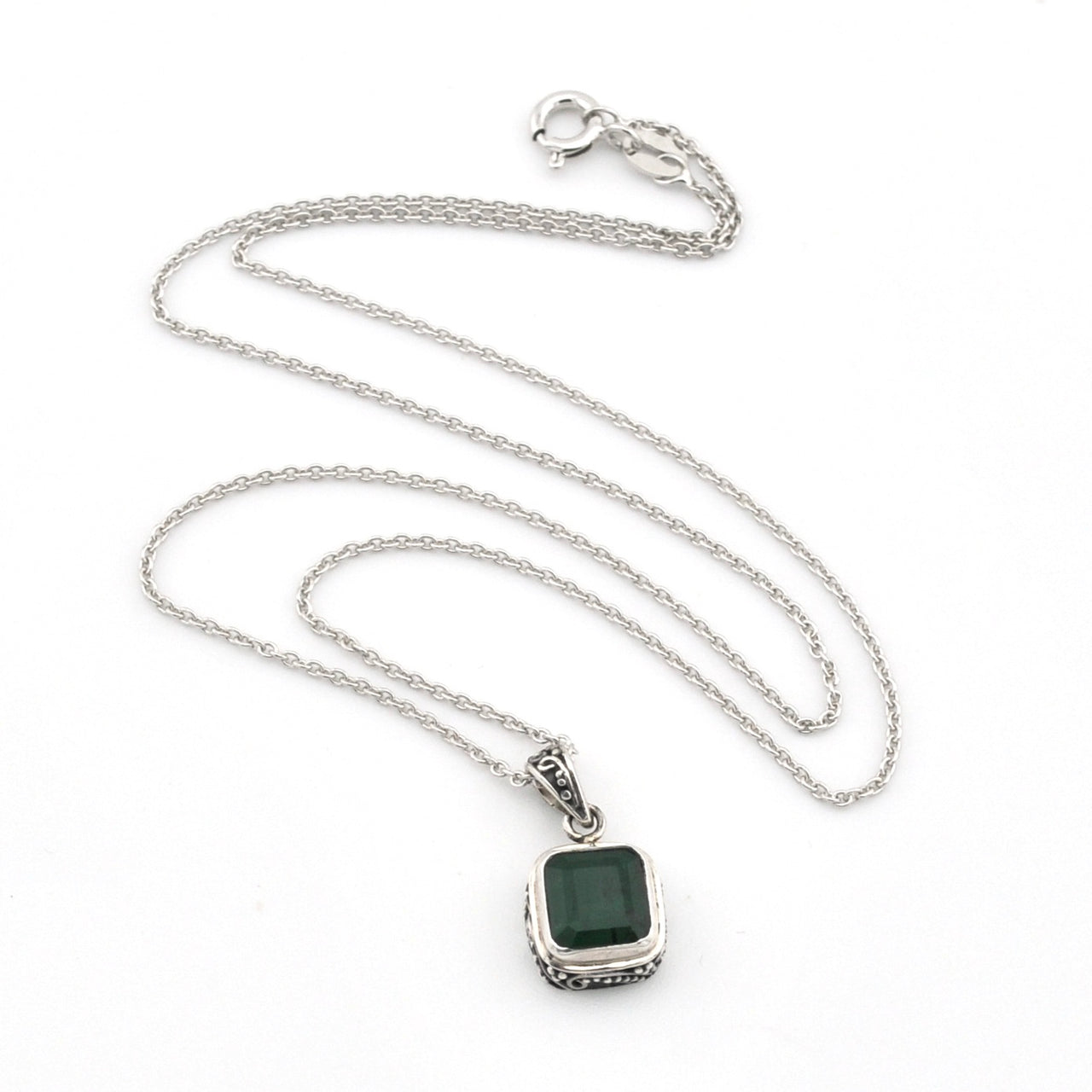 Silver necklace with a green gemstone pendant on a white background